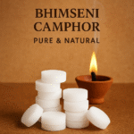 Bheemseni Camphor tablets, pure and natural, stacked next to a burning clay diya for sacred pooja rituals.