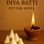 Ready-to-use Ghee Diya Batti cotton wicks stacked next to a burning clay diya for Hindu pooja.